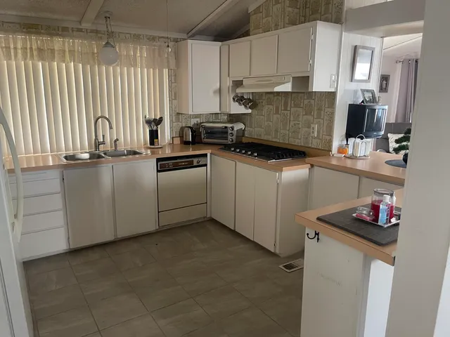 a kitchen with stainless steel appliances granite countertop a sink refrigerator and cabinets