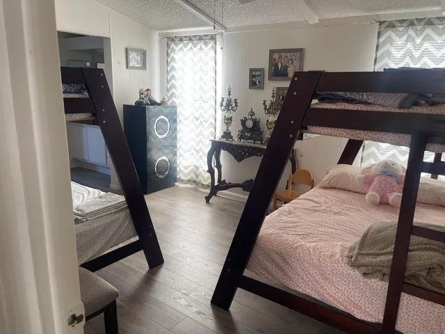a bed sitting in a bedroom next to a window
