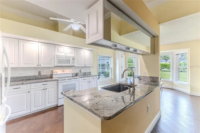 a kitchen with granite countertop a sink and cabinets