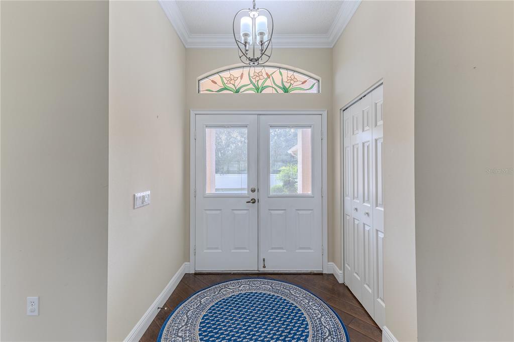 2181 Terrace View Lane Spring Hill, FL 34606 - Photo 7 of 60 a view of a hallway with wooden floor and a chandelier