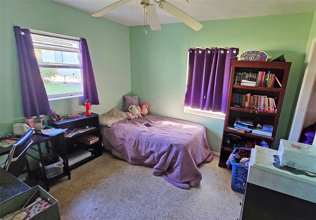 3310 Lexington Street Sarasota, FL 34231 - Photo 9 of 35 a bedroom with a bed and a book shelf