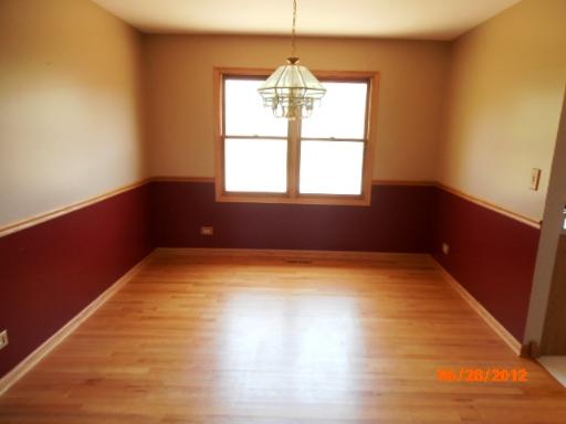 416 Fawn Lane Oswego, IL 60543 - Photo 2 of 15 a view of an empty room with wooden floor and a window