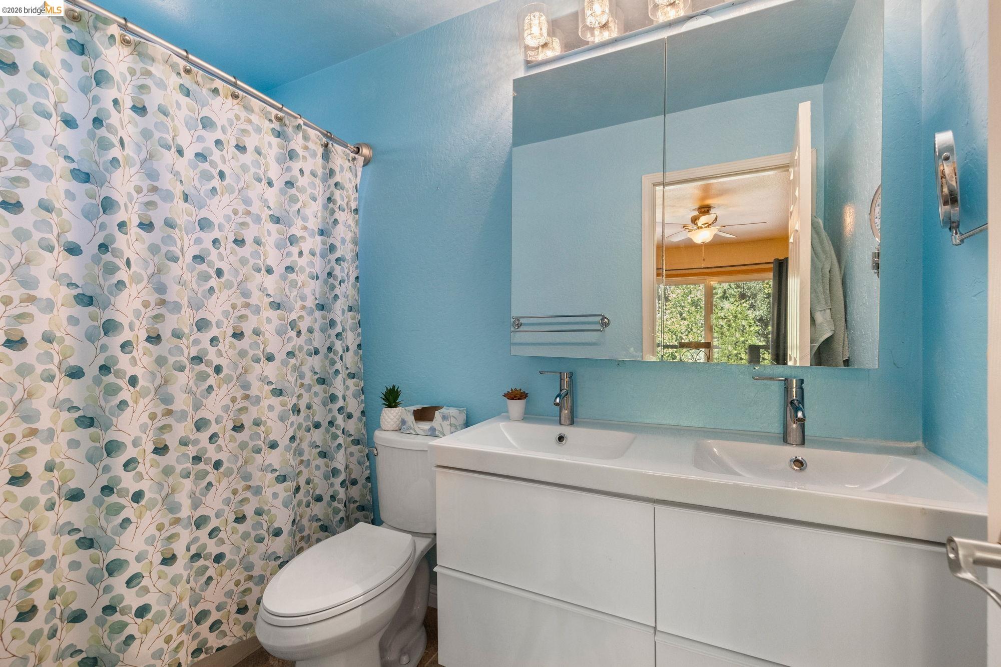 23615 Elizabeth Peak Road Twain Harte, CA 95383 - Photo 15 of 38 Bathroom featuring a shower with curtain, double vanity, and ceiling fan