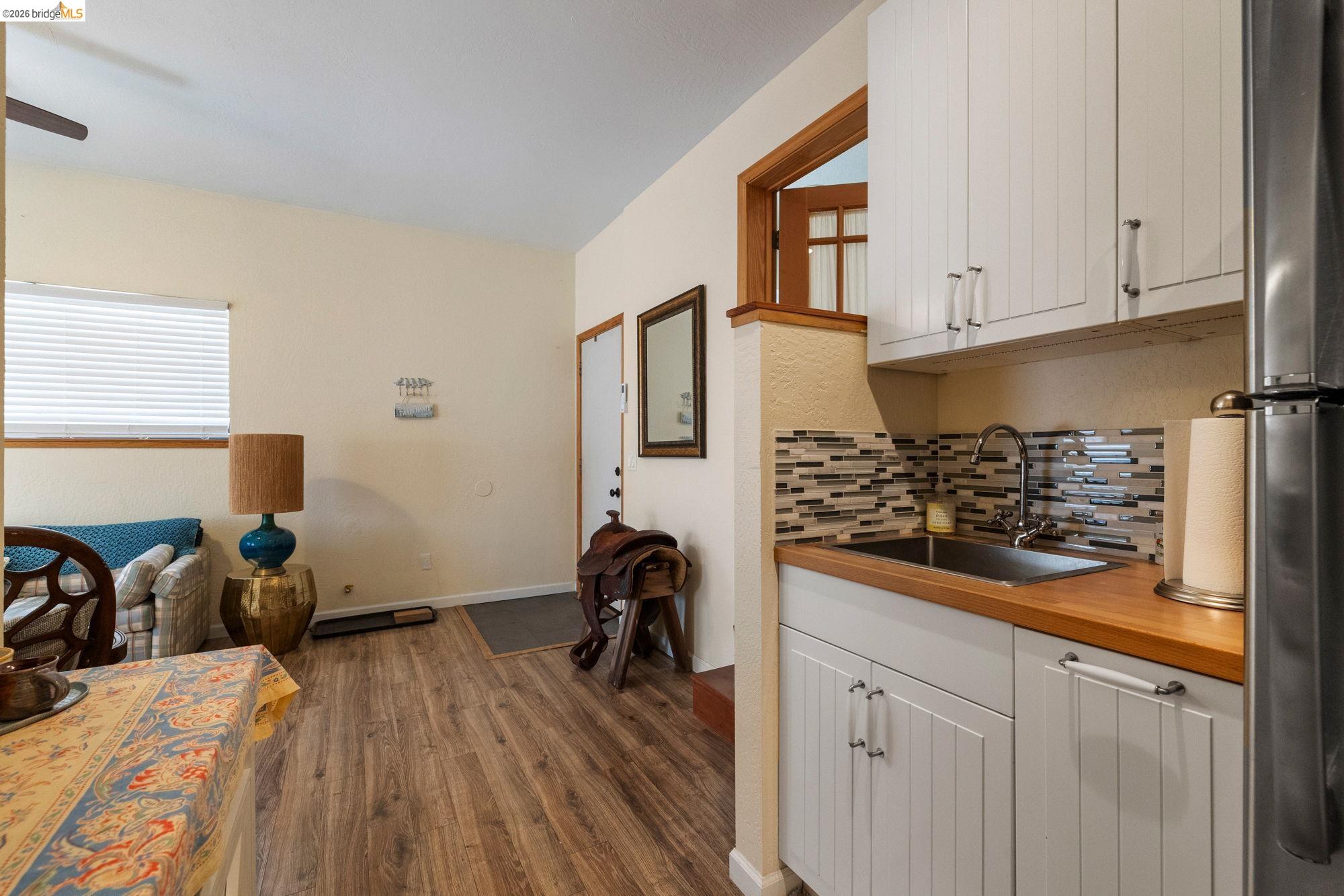 23615 Elizabeth Peak Road Twain Harte, CA 95383 - Photo 21 of 38 Kitchen featuring white cabinets, freestanding refrigerator, dark wood-style flooring, wooden counters, and backsplash