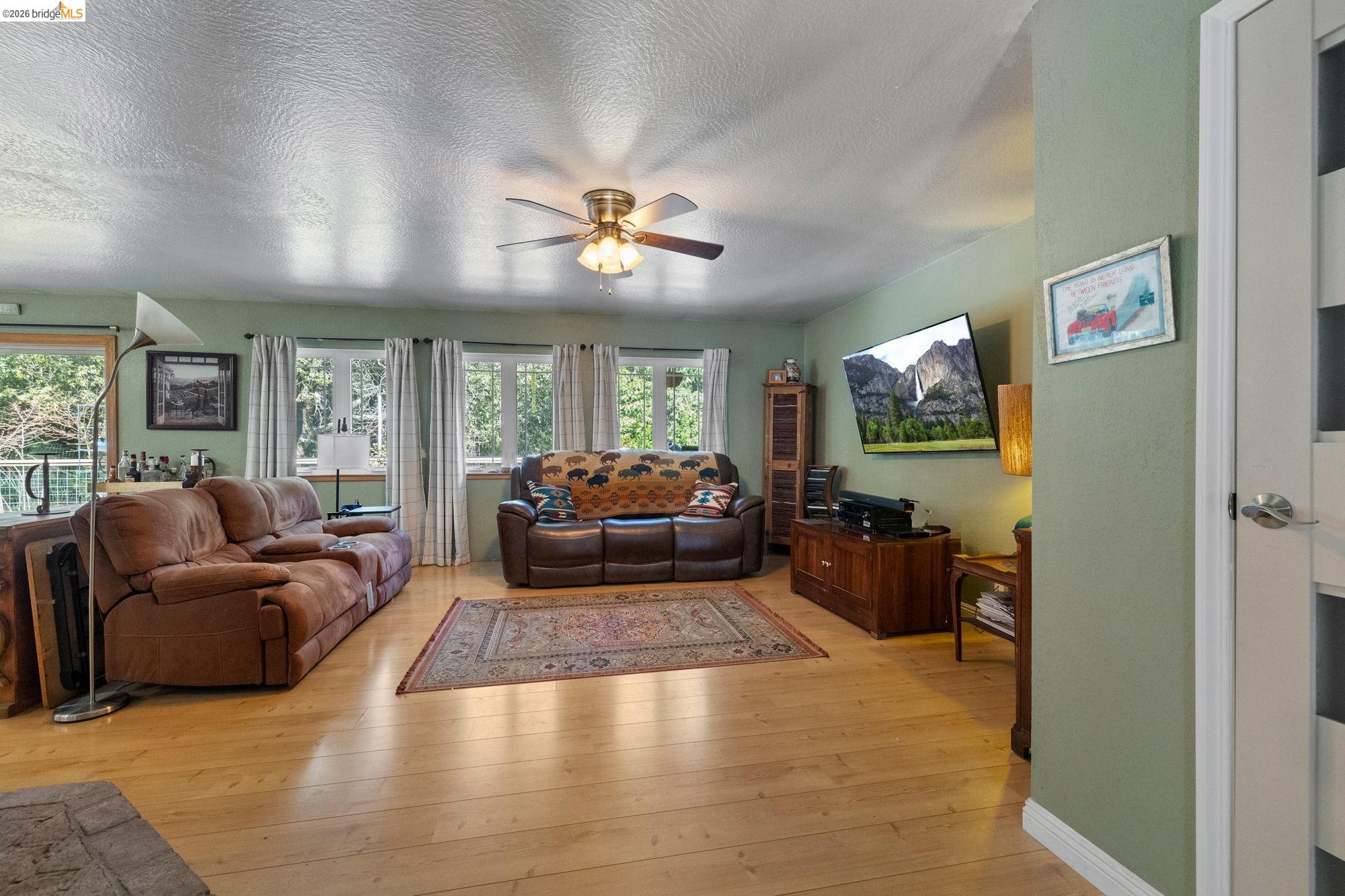 23615 Elizabeth Peak Road Twain Harte, CA 95383 - Photo 5 of 38 Living area with a textured ceiling, light wood-style floors, and ceiling fan