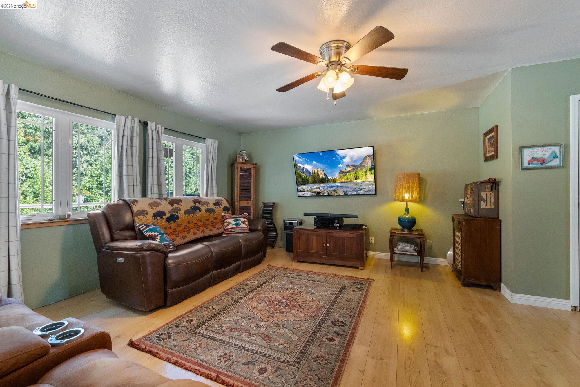 23615 Elizabeth Peak Road Twain Harte, CA 95383 - Photo 7 of 38 Living room with light wood-style floors, a ceiling fan, and a textured ceiling