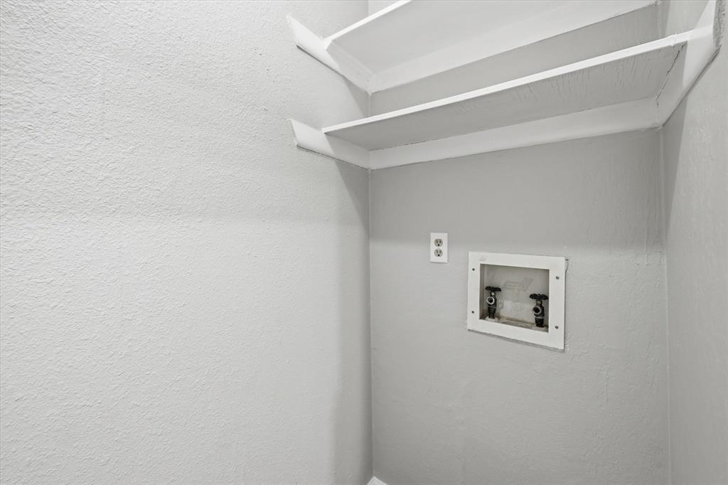9809 Matchpoint Place Dallas, TX 75243 - Photo 11 of 21 Downstairs Utility area with a neutral color palette, integrated wall shelving, a recessed hookup box, and an electrical outlet