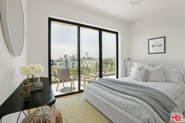 a bedroom with a bed and a large window