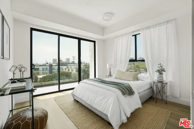 a bedroom with a bed and a large window