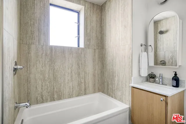 a bathroom with a tub sink and vanity