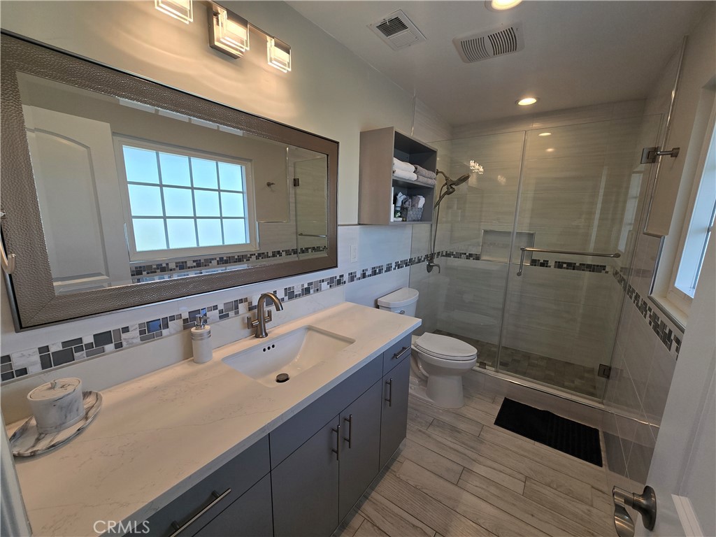 1925 South Kathy Lane Anaheim, CA 92802 - Photo 8 of 12 a spacious bathroom with a granite countertop sink a toilet a mirror and shower