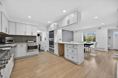 a kitchen with white cabinets and stainless steel appliances