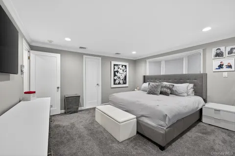 a spacious bedroom with a bed and a flat screen tv