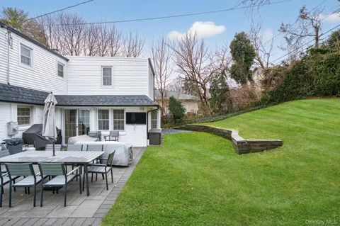 a view of a house with backyard sitting area and garden