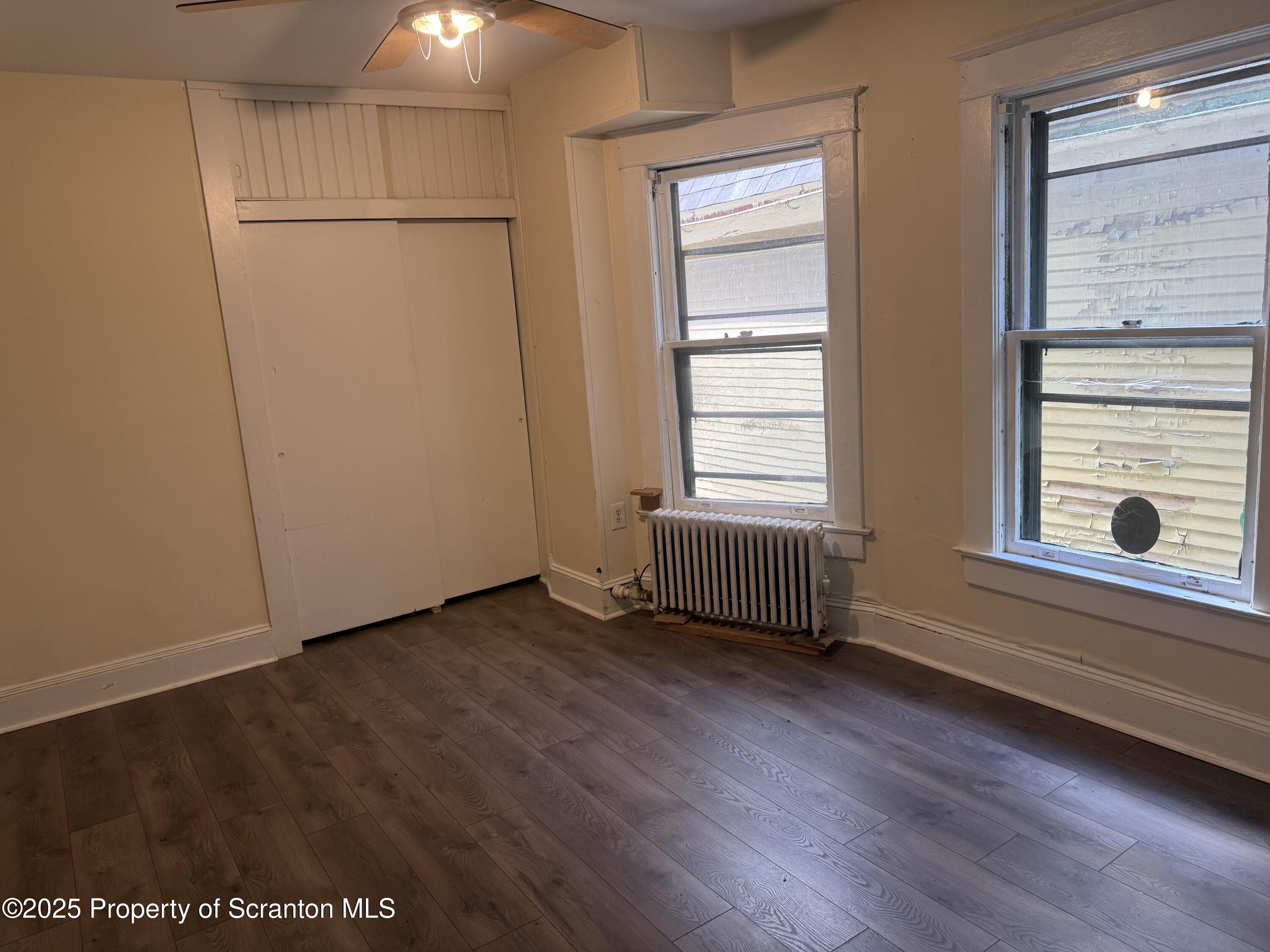 315 Wheeler Avenue Scranton, PA 18510 - Photo 14 of 18 a view of an empty room with a window and wooden floor