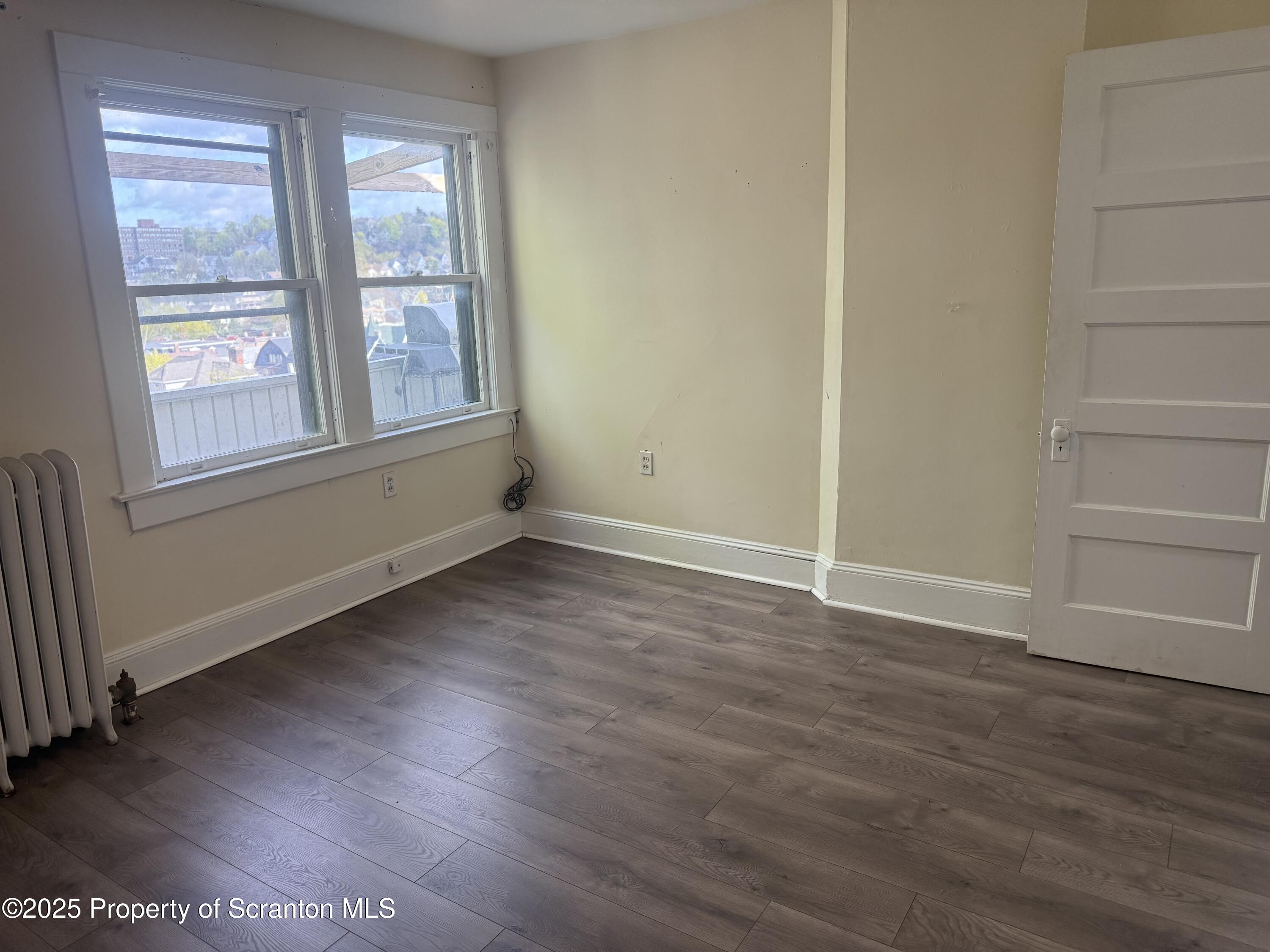 315 Wheeler Avenue Scranton, PA 18510 - Photo 18 of 18 an empty room with wooden floor and windows