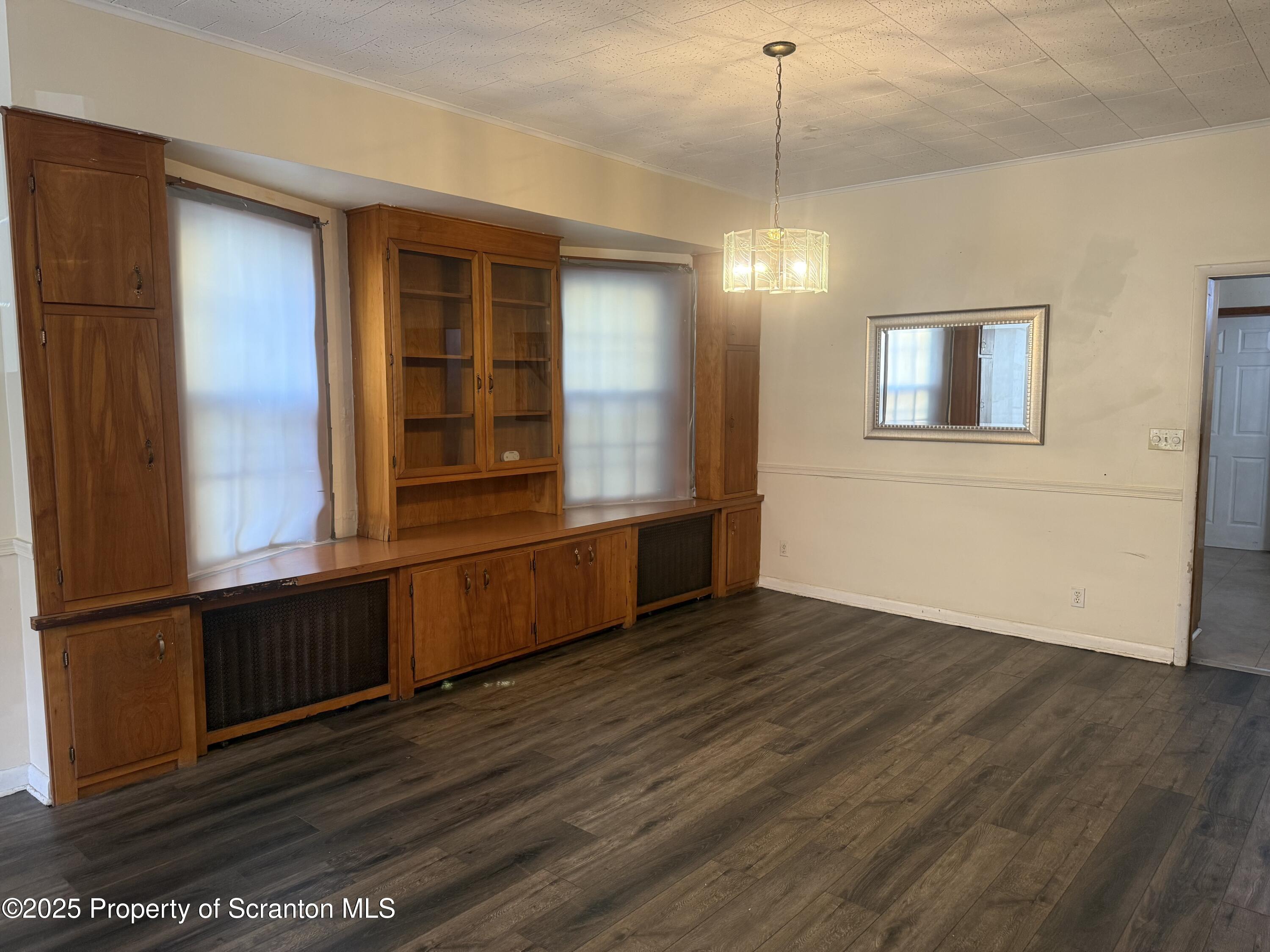 315 Wheeler Avenue Scranton, PA 18510 - Photo 3 of 18 a view of an empty room with wooden floor and a window