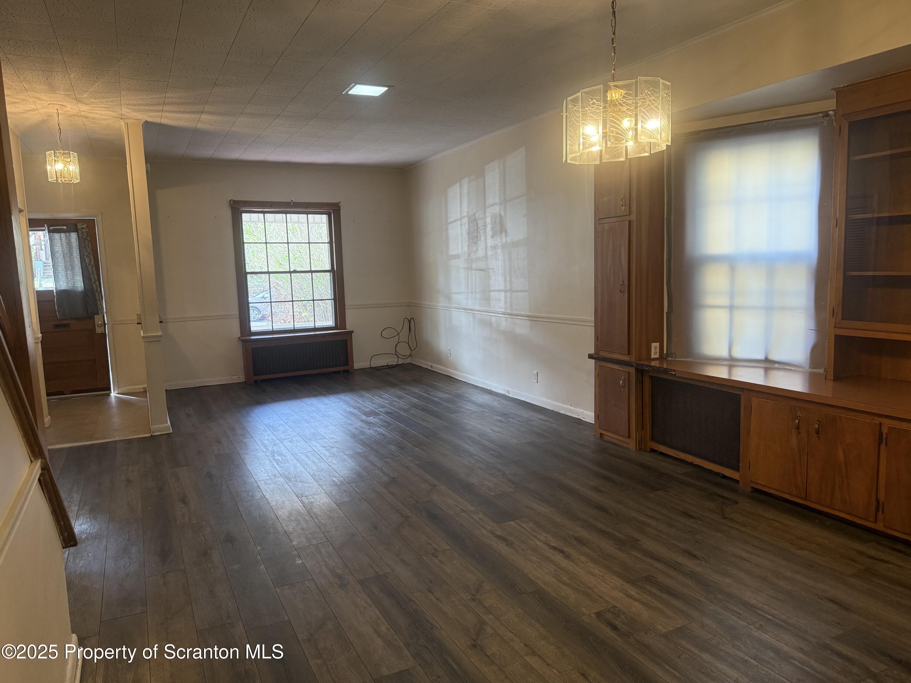 315 Wheeler Avenue Scranton, PA 18510 - Photo 4 of 18 an empty room with wooden floor and windows