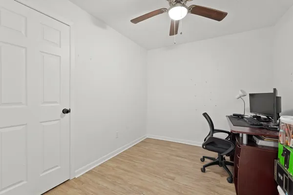 a view of a workspace with furniture and a ceiling fan