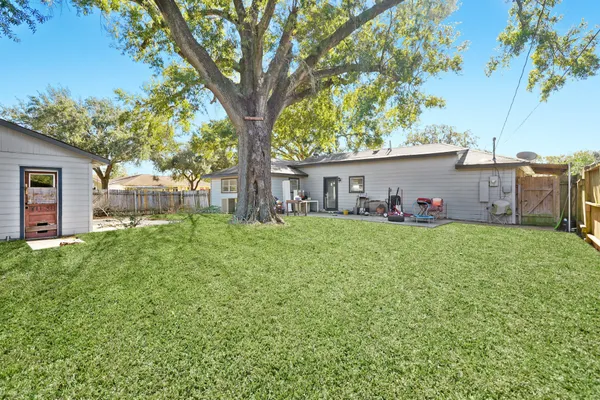 a front view of a house with a big yard and large tree