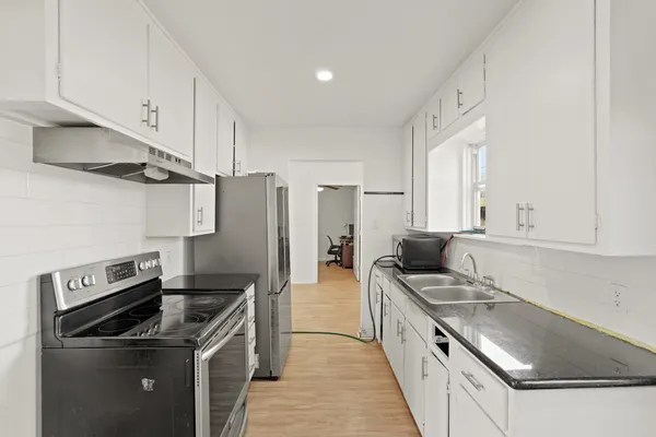 a kitchen with stainless steel appliances granite countertop a sink stove and refrigerator