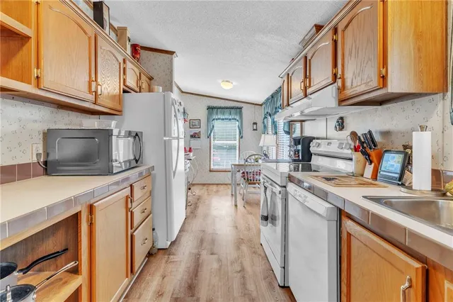 a kitchen with stainless steel appliances granite countertop a sink a stove and a refrigerator
