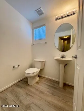 a bathroom with a toilet a sink and mirror