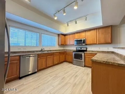 a kitchen with granite countertop stainless steel appliances and wooden cabinets