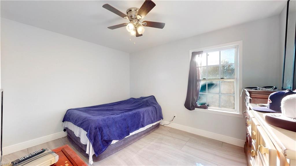 3903 35th Street Southwest Lehigh Acres, FL 33976 - Photo 11 of 16 a living room with a bed furniture and a window