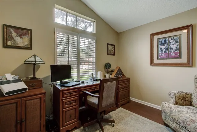 a view of a workspace with furniture and a window