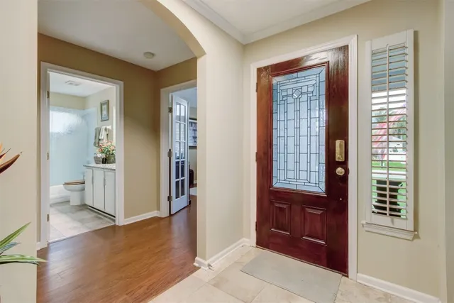 a view of a hallway with bathroom and wooden floor