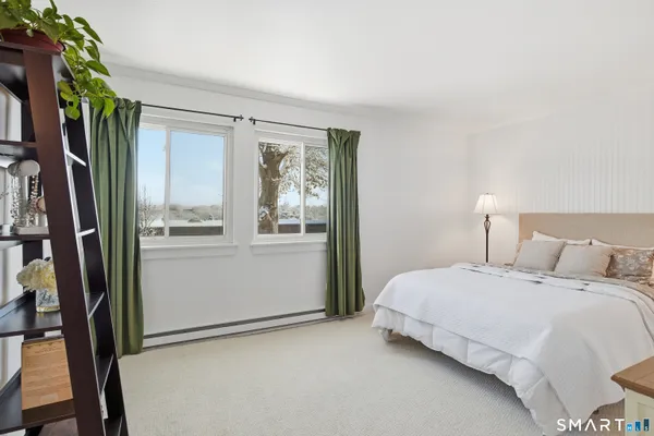 a bedroom with a bed next to a window