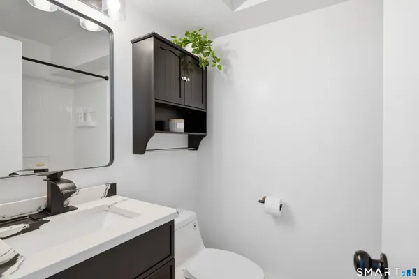 a bathroom with a sink vanity mirror and toilet