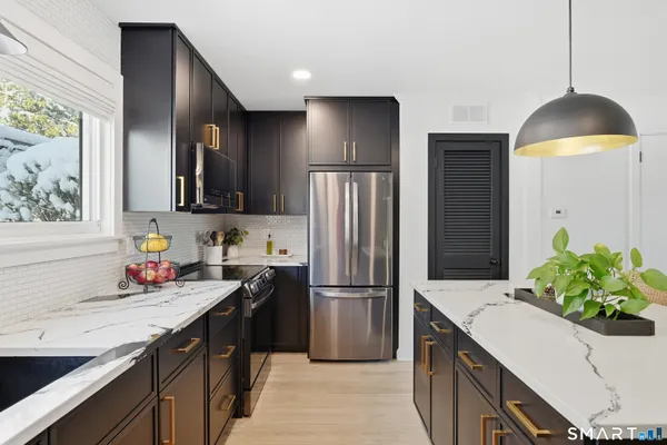 a kitchen with granite countertop a refrigerator and a sink