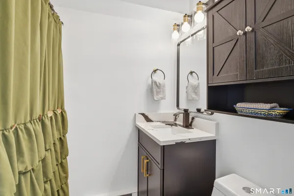 a bathroom with a sink a toilet and a mirror
