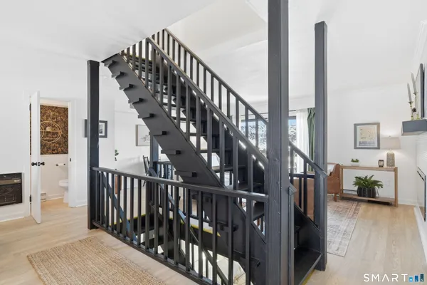 a view of staircase with lots of frames on wall and a wooden floor
