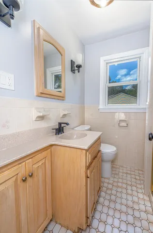 a bathroom with a sink a toilet a mirror and vanity