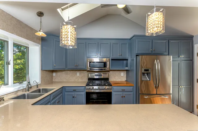 a kitchen with a refrigerator a stove a sink and a window