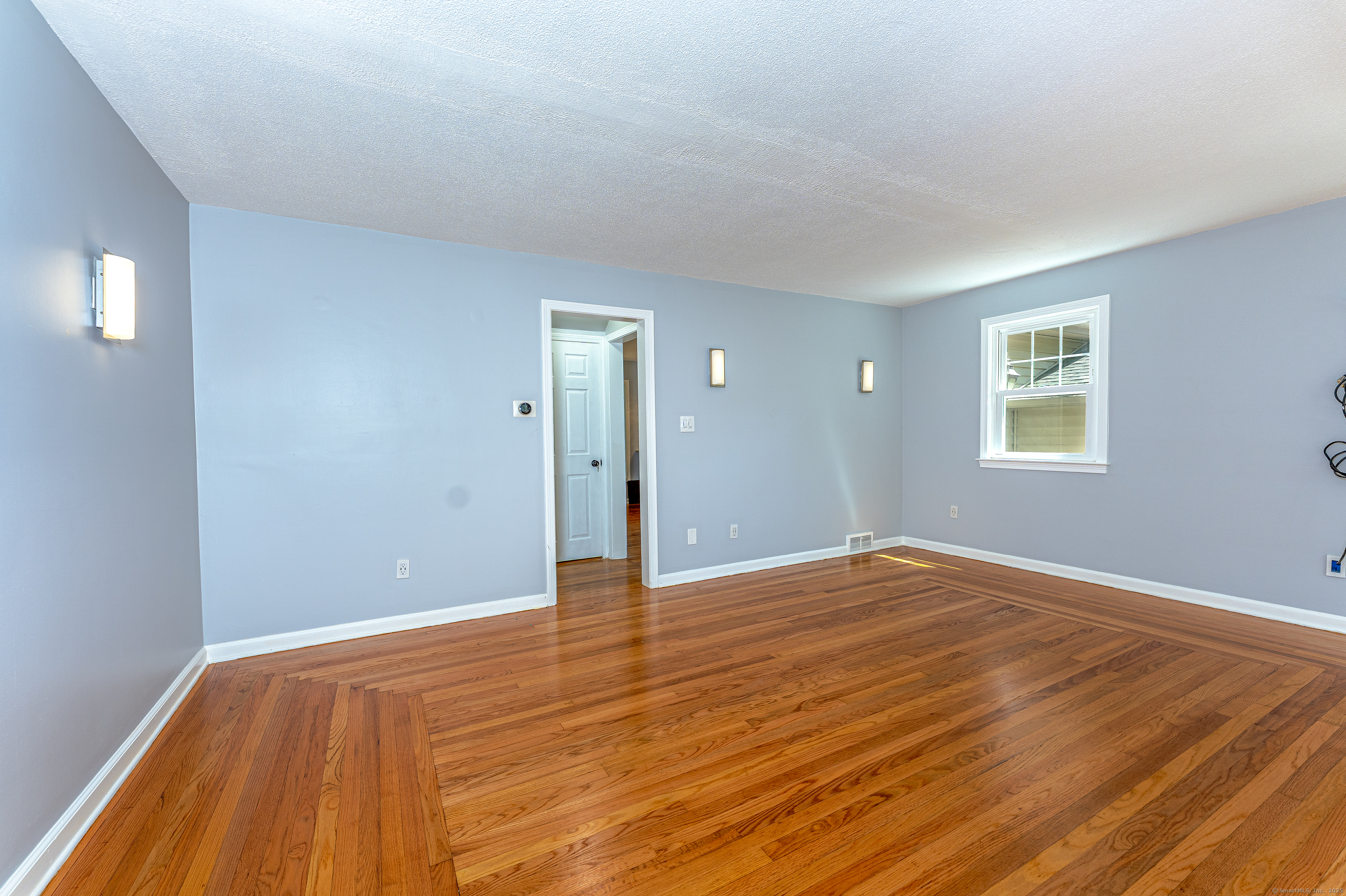 8 Ranslow Drive Wolcott, CT 06716 - Photo 6 of 31 a view of an empty room with wooden floor and a window