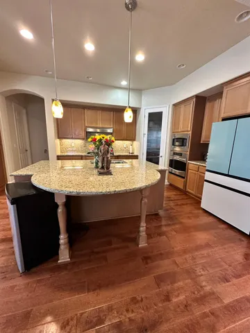 a view of kitchen with sink refrigerator and microwave