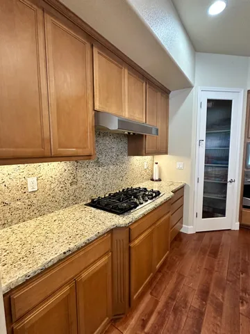a kitchen with granite countertop wooden cabinets and stainless steel appliances