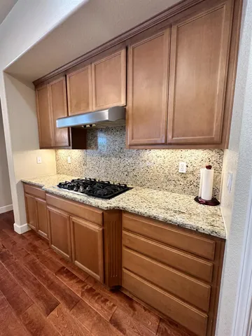 a kitchen with granite countertop cabinets stainless steel appliances and a counter space