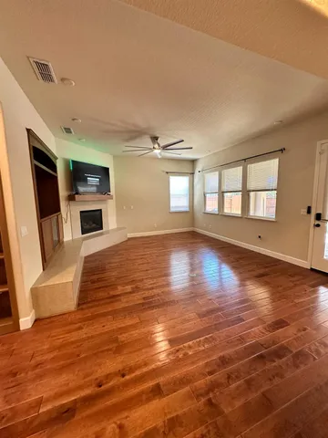 a view of a livingroom with wooden floor and a fireplace