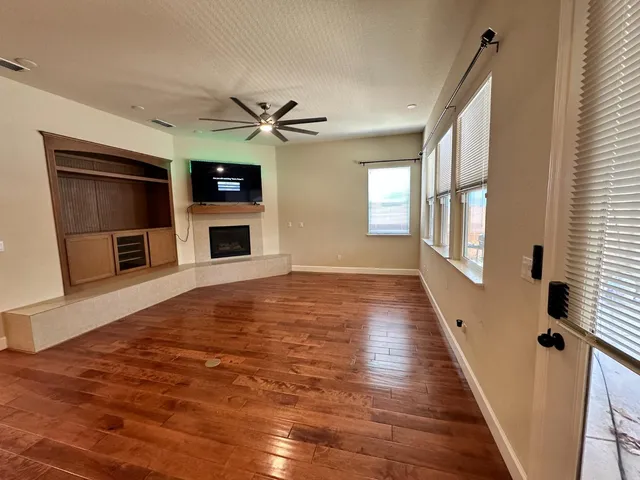 a view of a livingroom with wooden floor and a fireplace