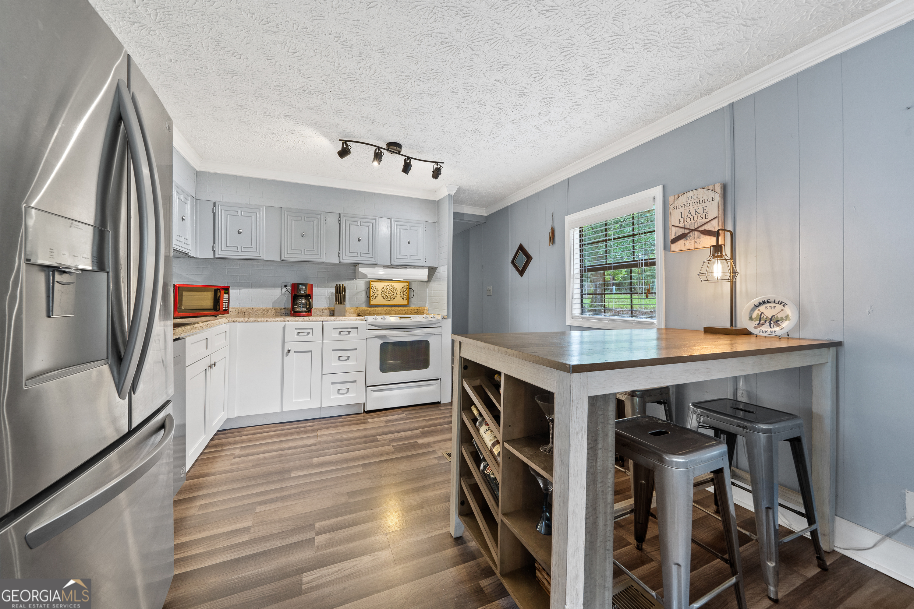 321 Barbara Point Road Sparta, GA 31087 - Photo 11 of 55 a kitchen with granite countertop a stove a sink and wooden floor