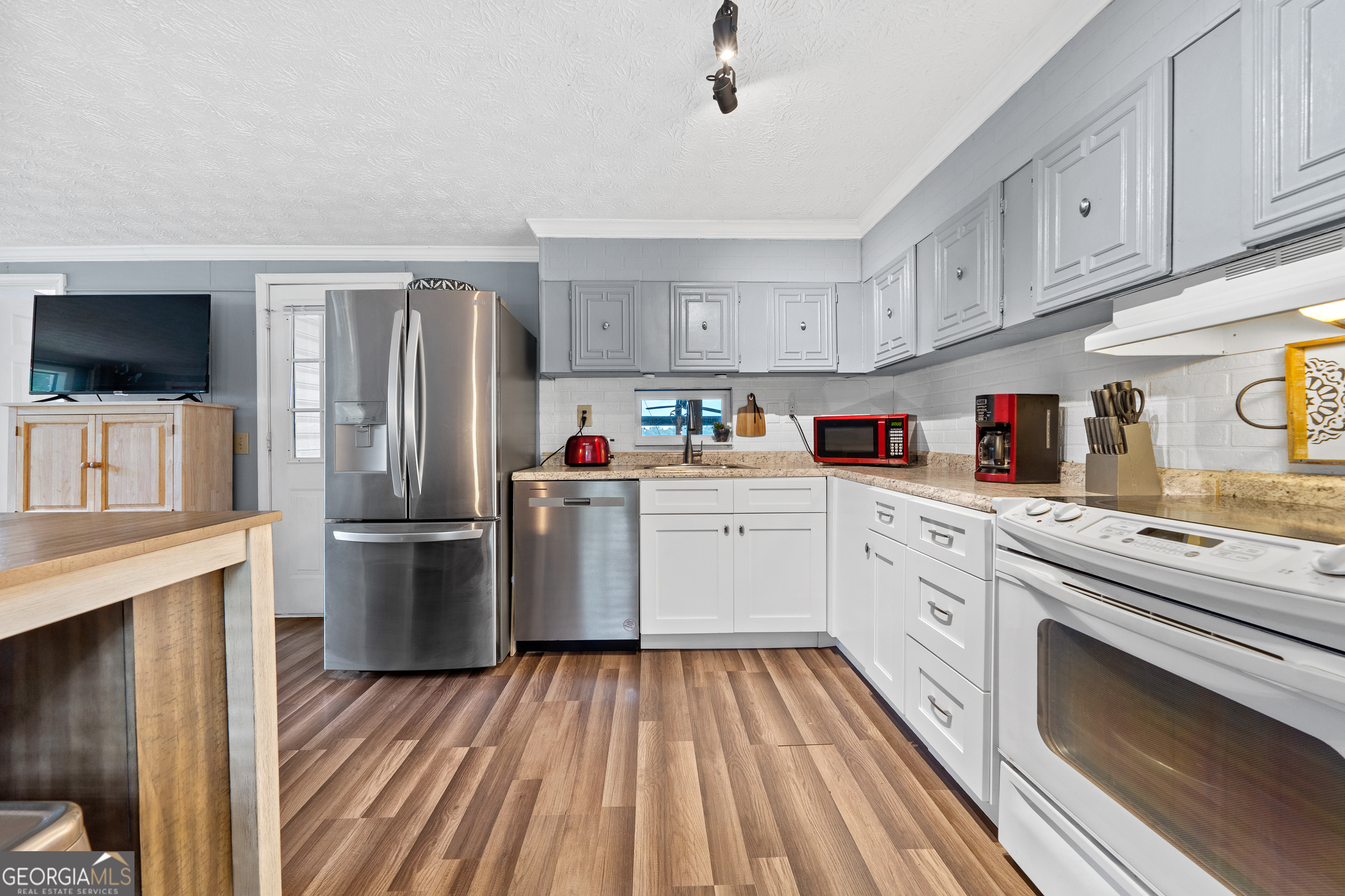 321 Barbara Point Road Sparta, GA 31087 - Photo 15 of 55 a kitchen with refrigerator cabinets and wooden floor
