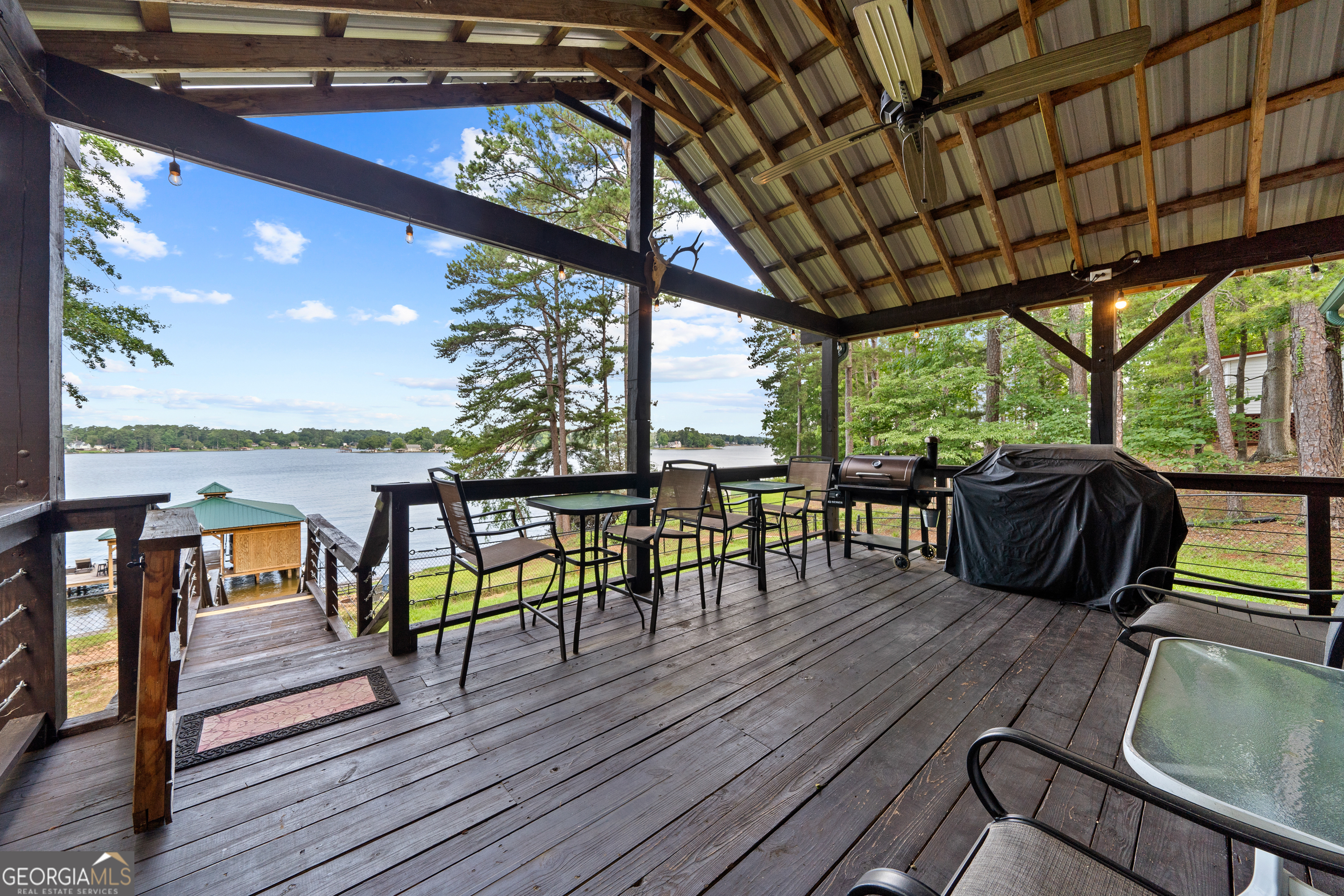 321 Barbara Point Road Sparta, GA 31087 - Photo 33 of 55 a view of a balcony with chairs and wooden floor