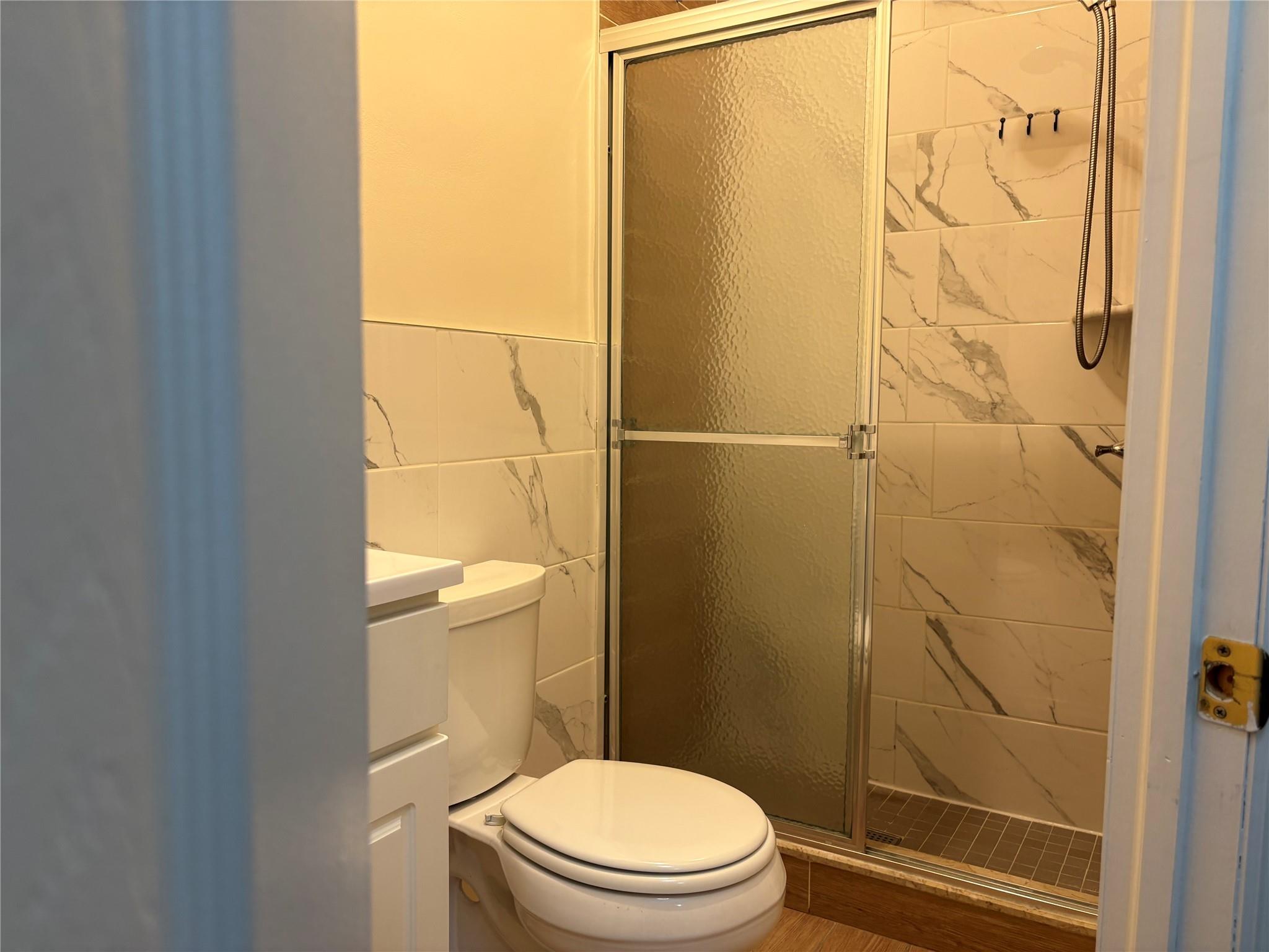 262 Grant Avenue Brooklyn, NY 11208 - Photo 11 of 14 a white toilet sitting next to a shower curtain