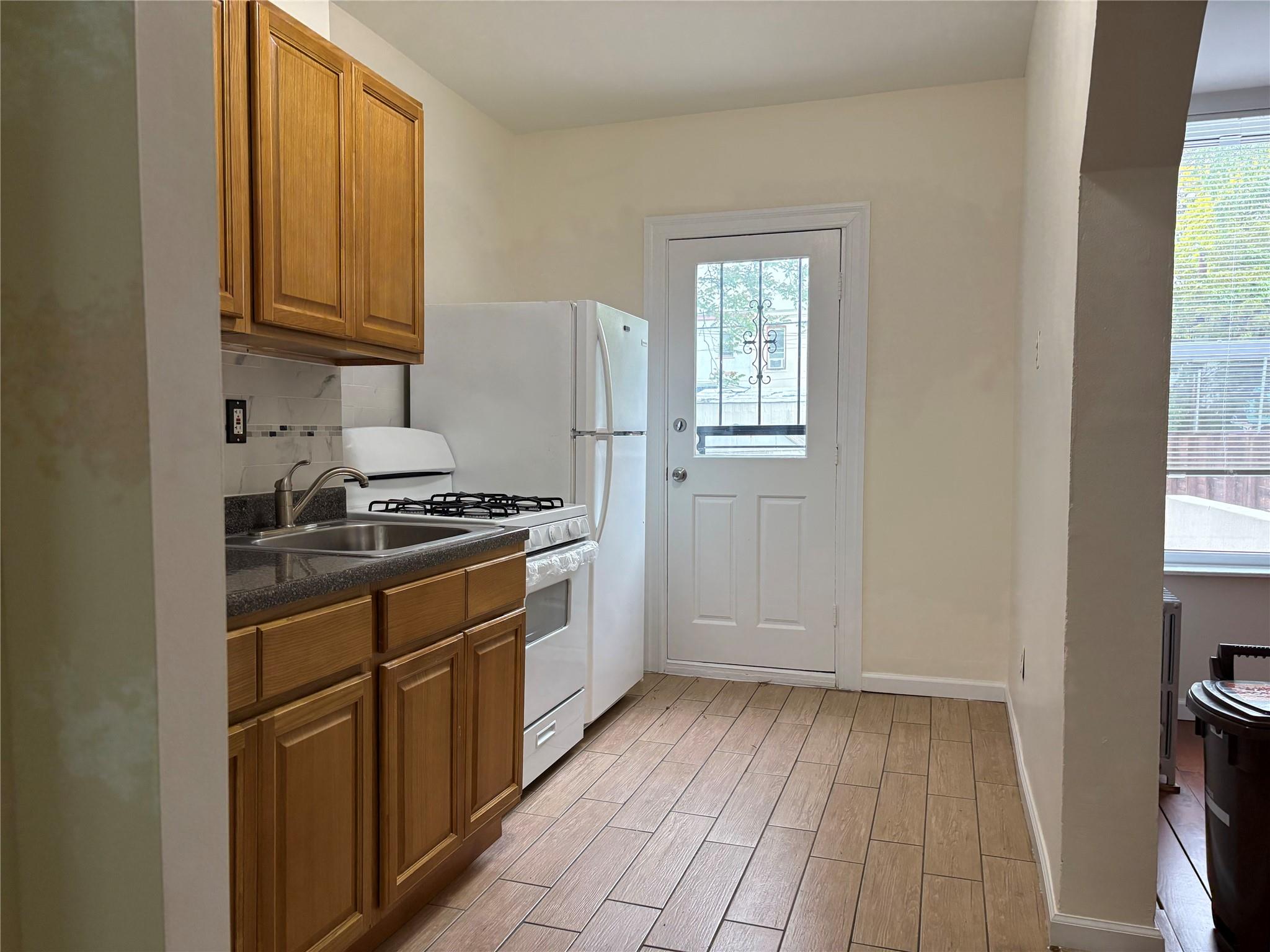 262 Grant Avenue Brooklyn, NY 11208 - Photo 5 of 14 a kitchen with cabinets appliances and a window