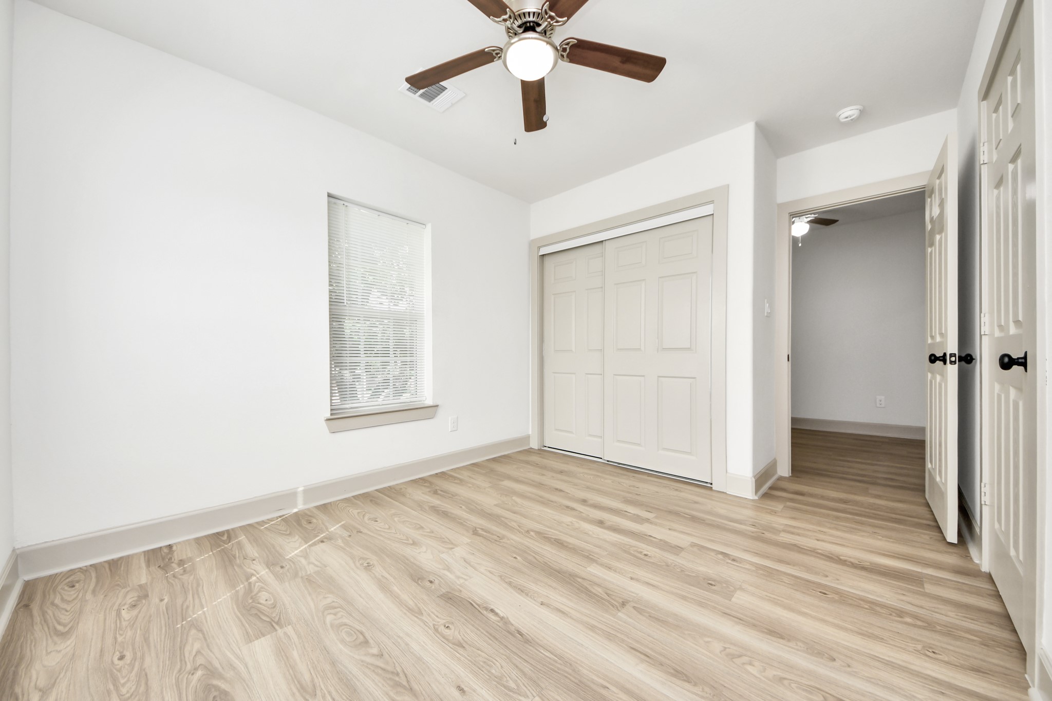 2919 Rosedale Street, Unit B Houston, TX 77004 - Photo 19 of 35 a view of an empty room with wooden floor and a ceiling fan